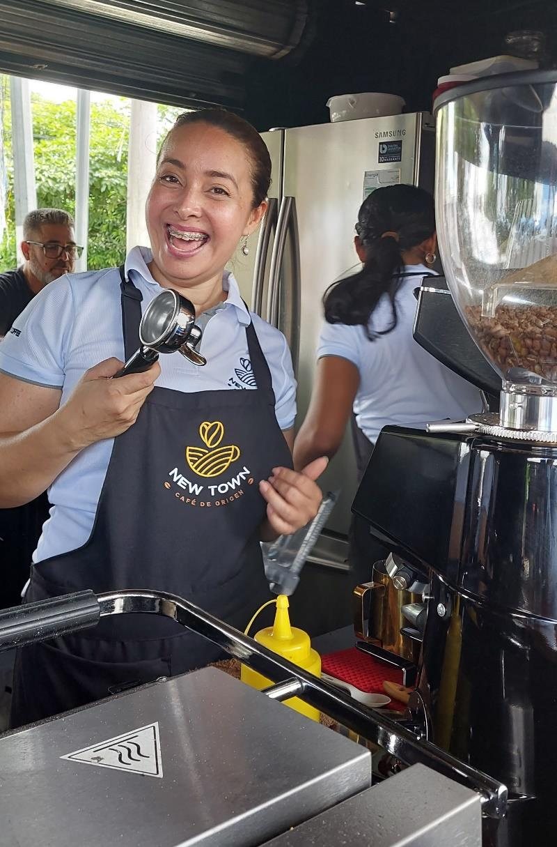 Participante sonriendo durante una práctica de barismo en un taller de SDC Consultores